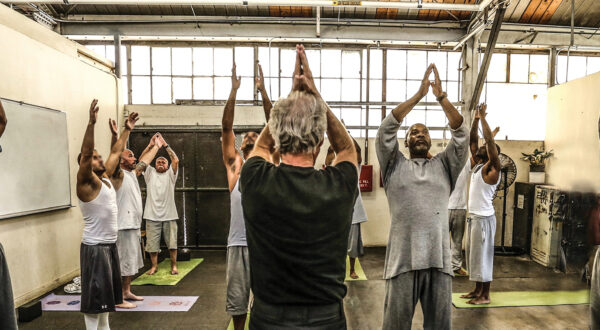 Inmates in a room doing yoga | Prison Yoga