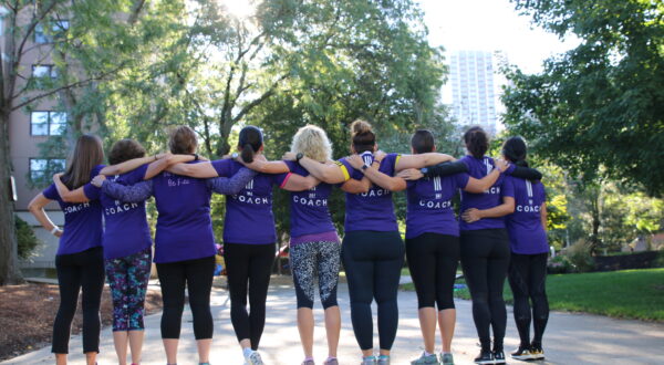 women in purple t-shirts linking arms