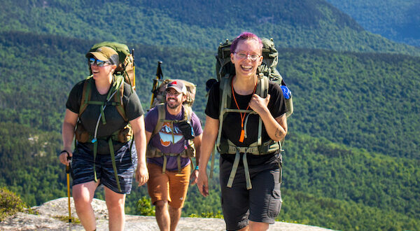 three hikers with mountain backdrop