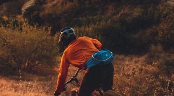 Kid mountain biking down dirt trail